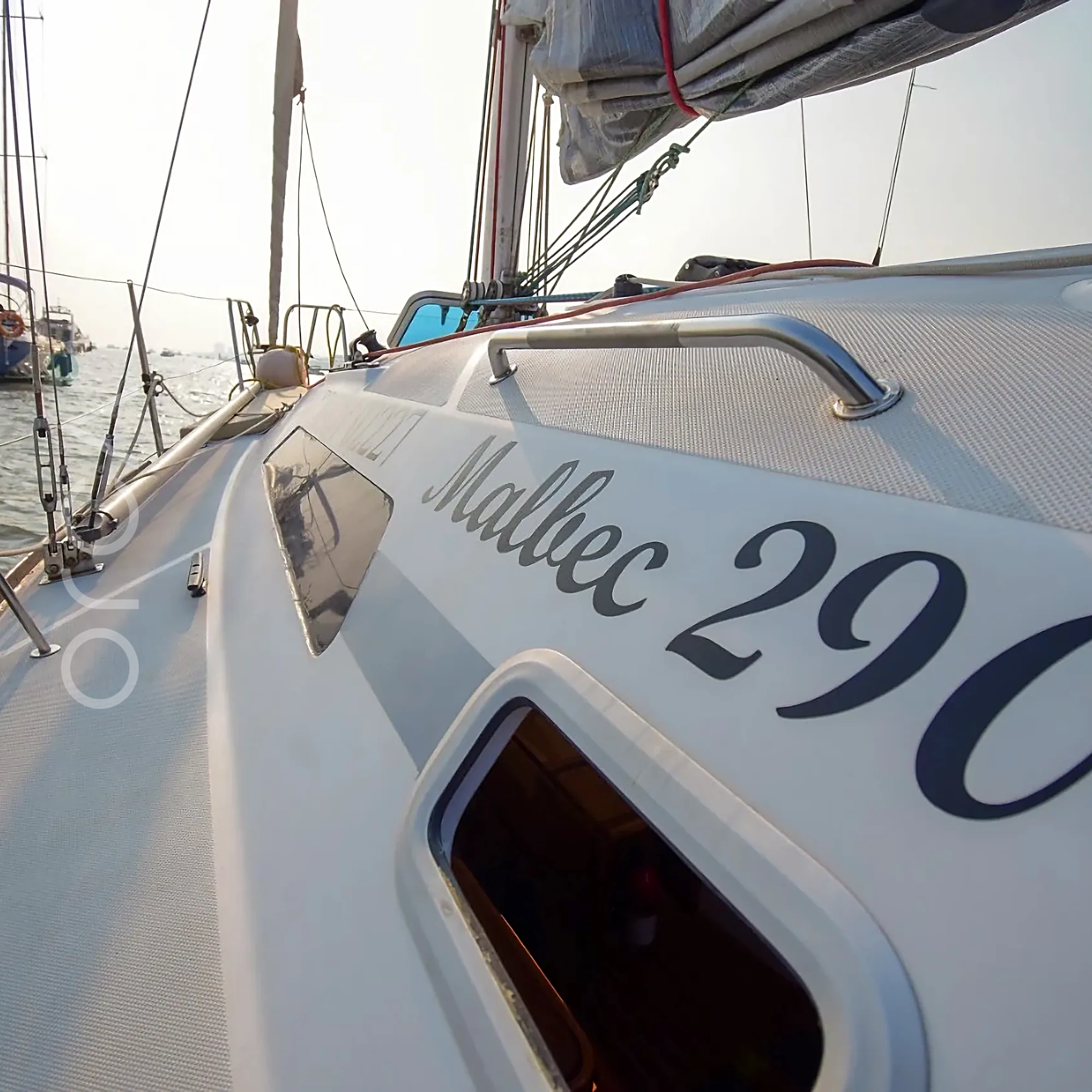 A Malbec 290 sailing yacht in Mumbai, the builder's mark on the topside, available to rent from Orca Sail.