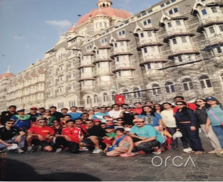 Corporate group photographed outside the Taj Mahal Palace before a Mumbai harbour sail with Orca Sail