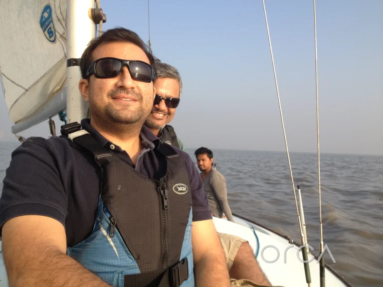 Friends sailing a J24 yacht together in Mumbai