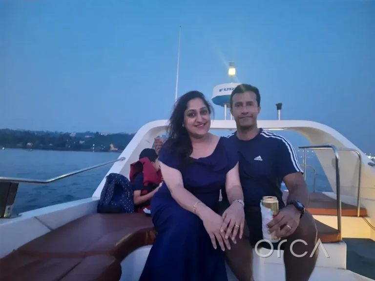 A couple on the deck of a motor yacht during a sunset cruise in Goa