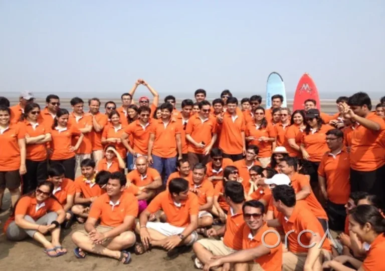 A corporate team photographed on the beach after a sailing day with Orca Sail
