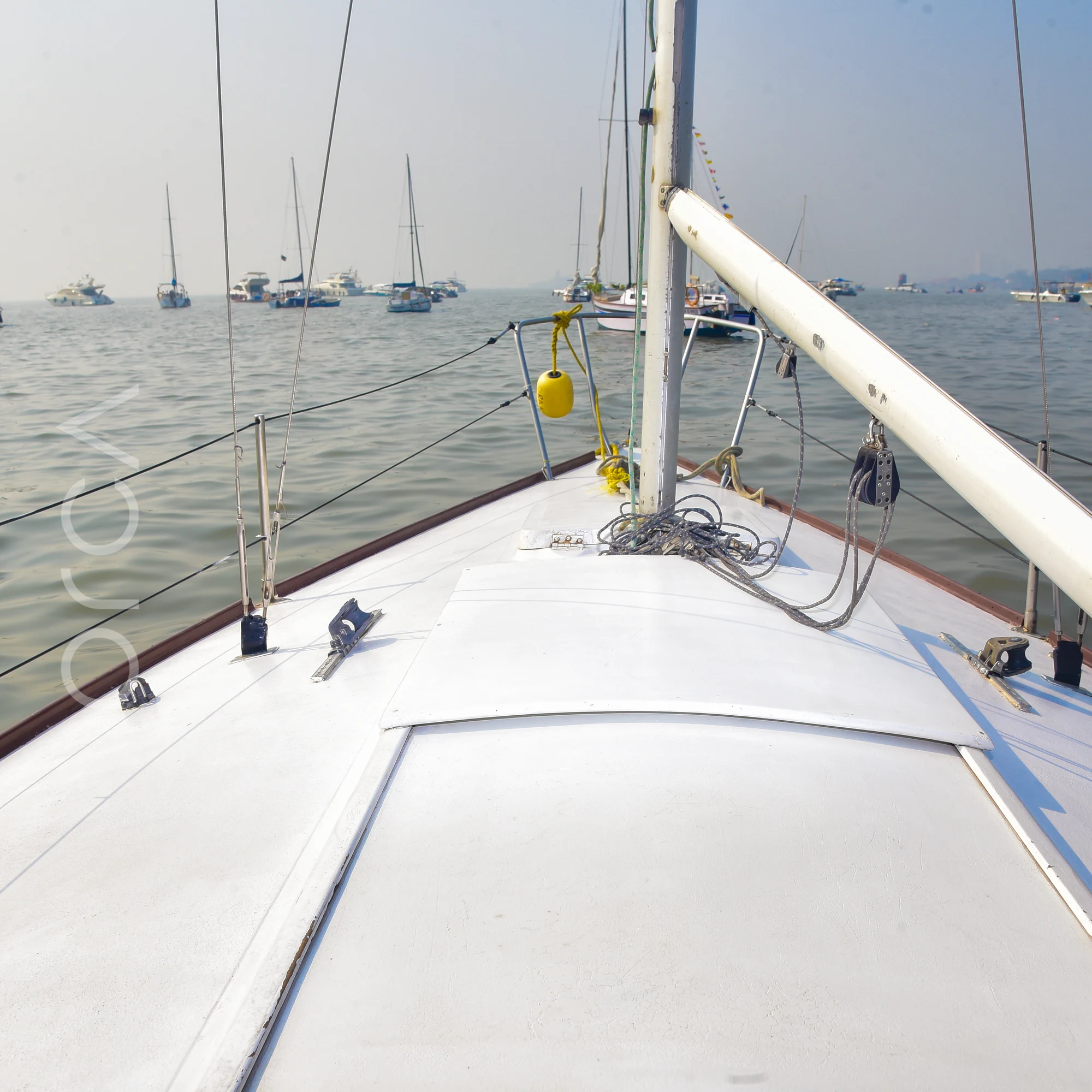 The foredeck of a J24 sailboat in Mumbai, looking forward past the mast.