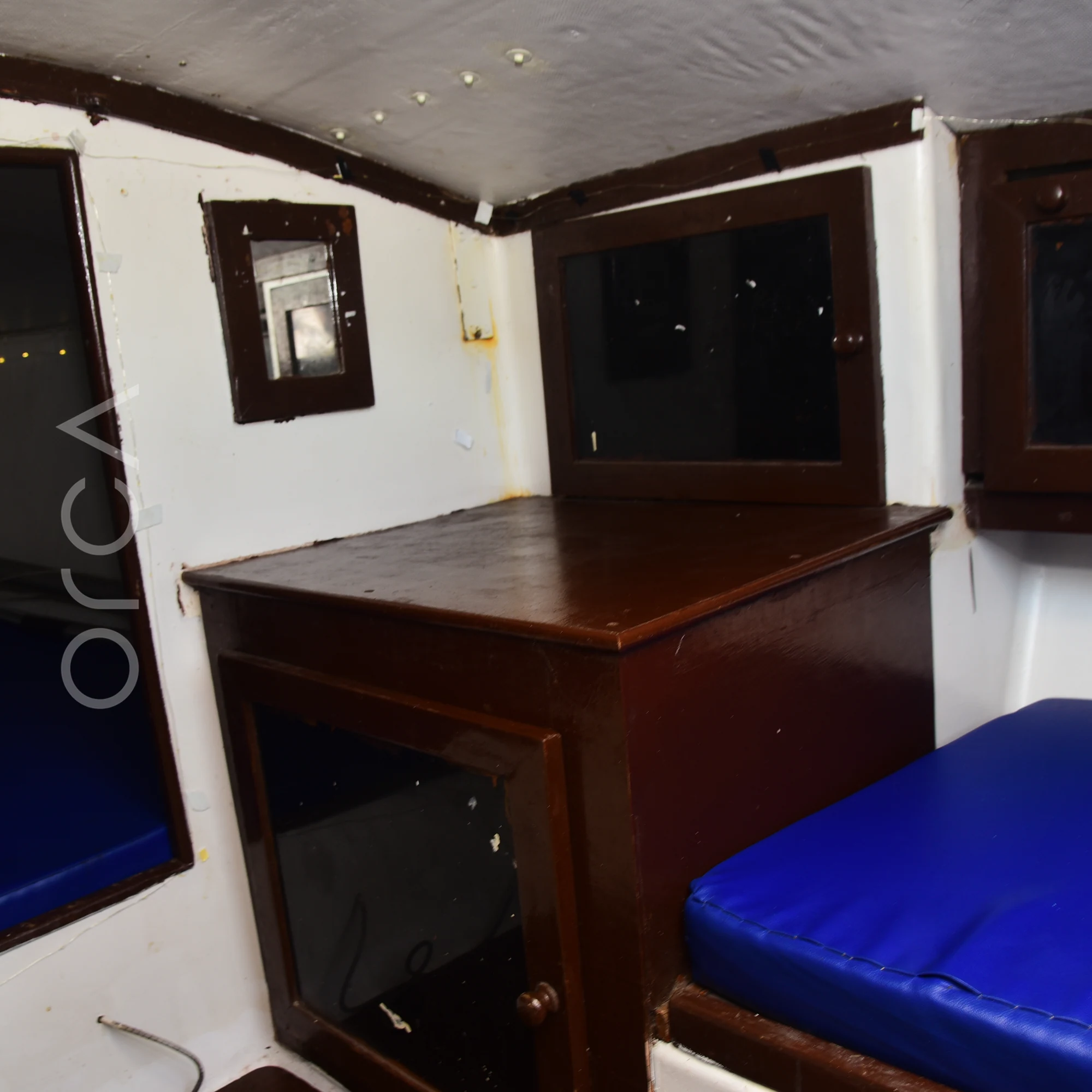The cabin of a J24 sailboat in Mumbai, with cushioned berths on each side.