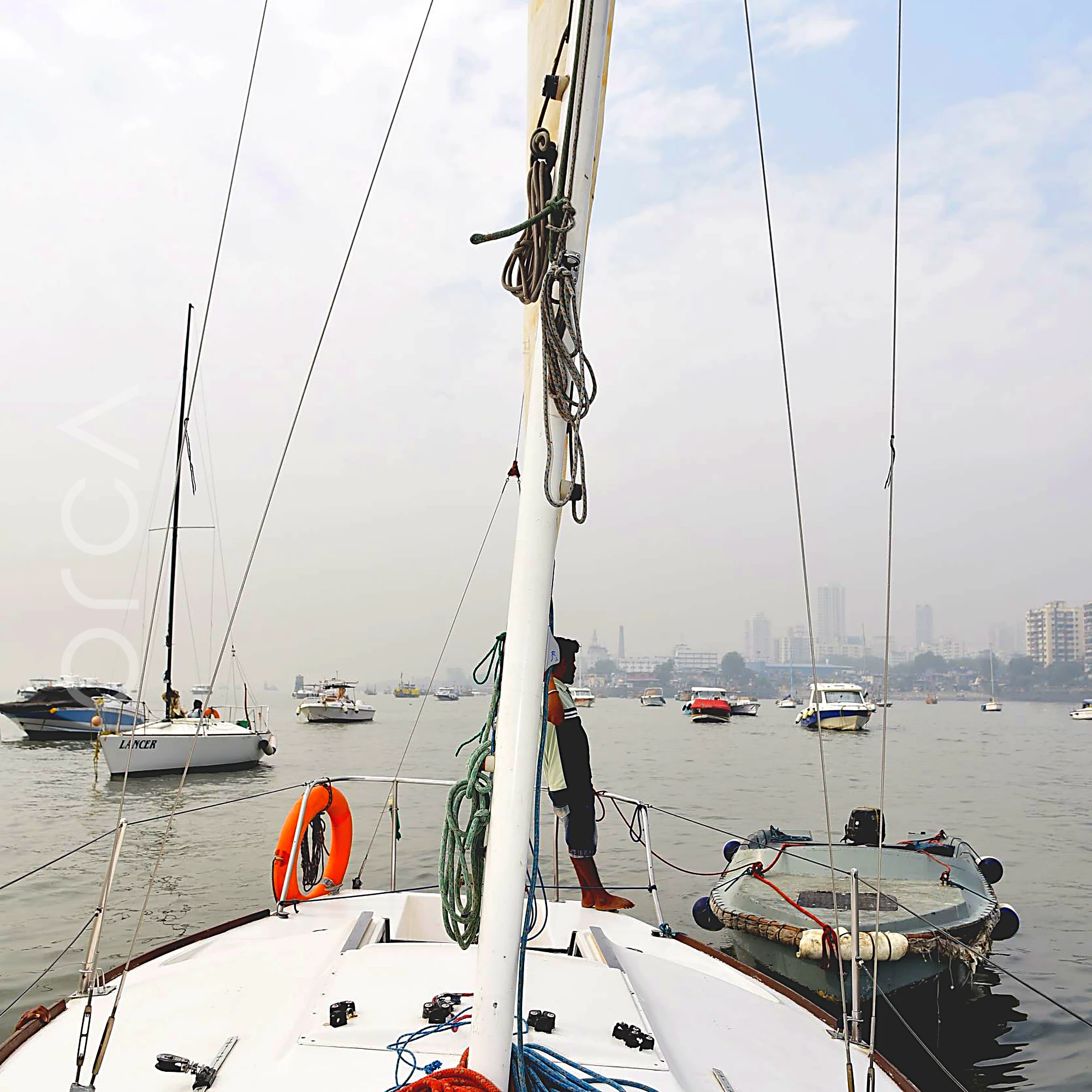 The foredeck of a J24 sailboat in Mumbai, looking forward past the mast.
