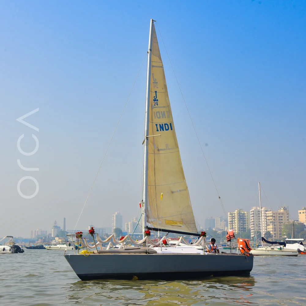 A J24 sailboat under sail in Mumbai harbour, available to rent from Orca Sail.