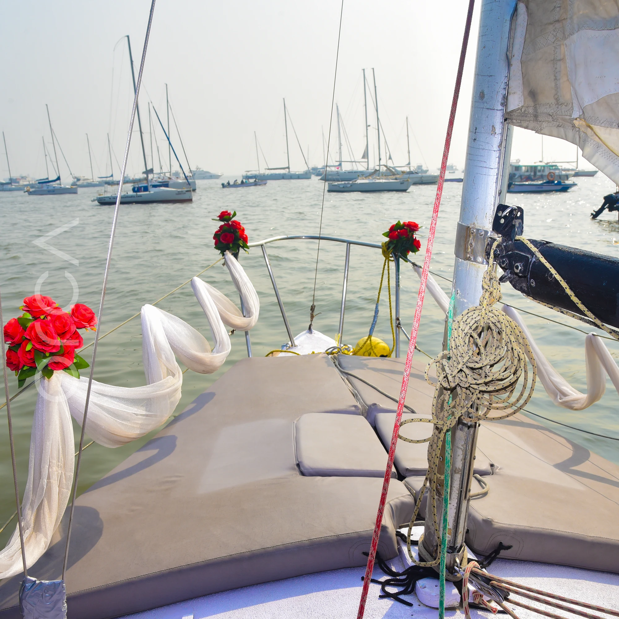 The foredeck of a J24 sailboat in Mumbai, dressed with roses and ribbons for a celebration.