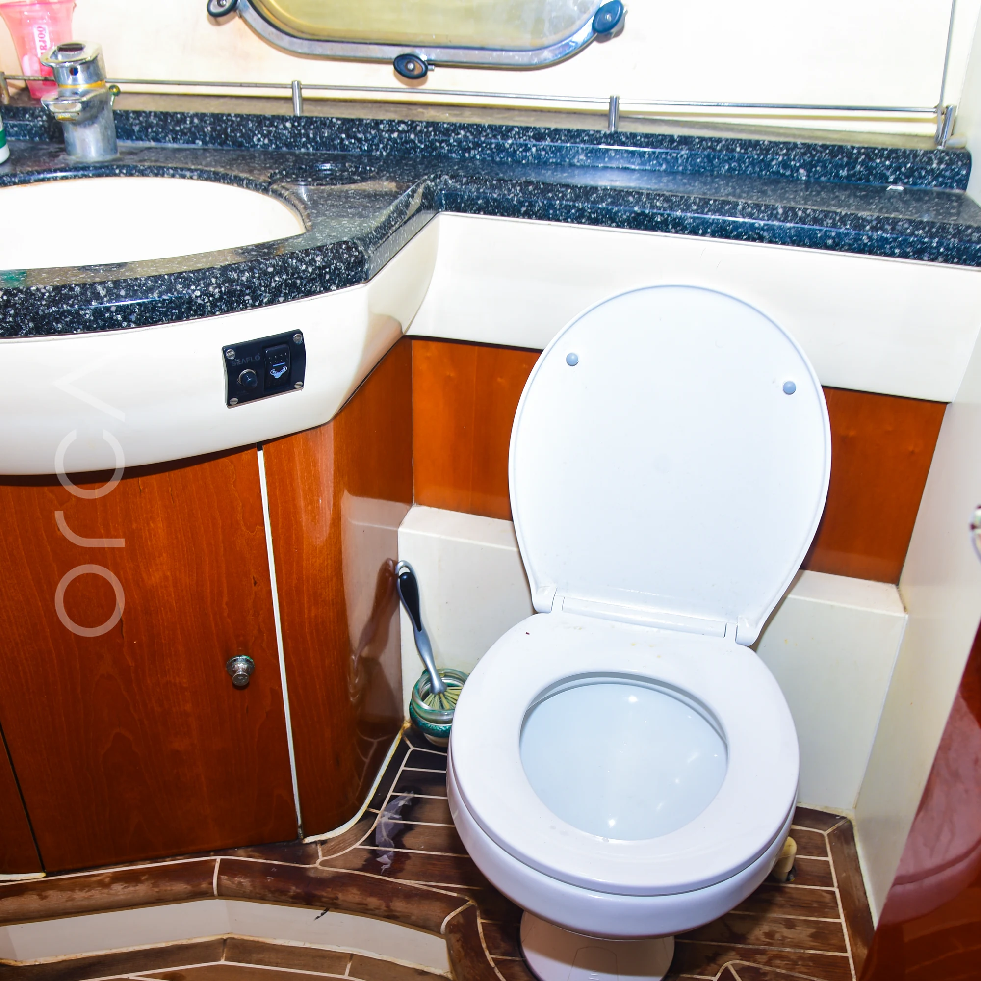 A bathroom aboard a Princess 61 motor yacht in Mumbai, with a basin and a marine toilet, available to rent from Orca Sail.