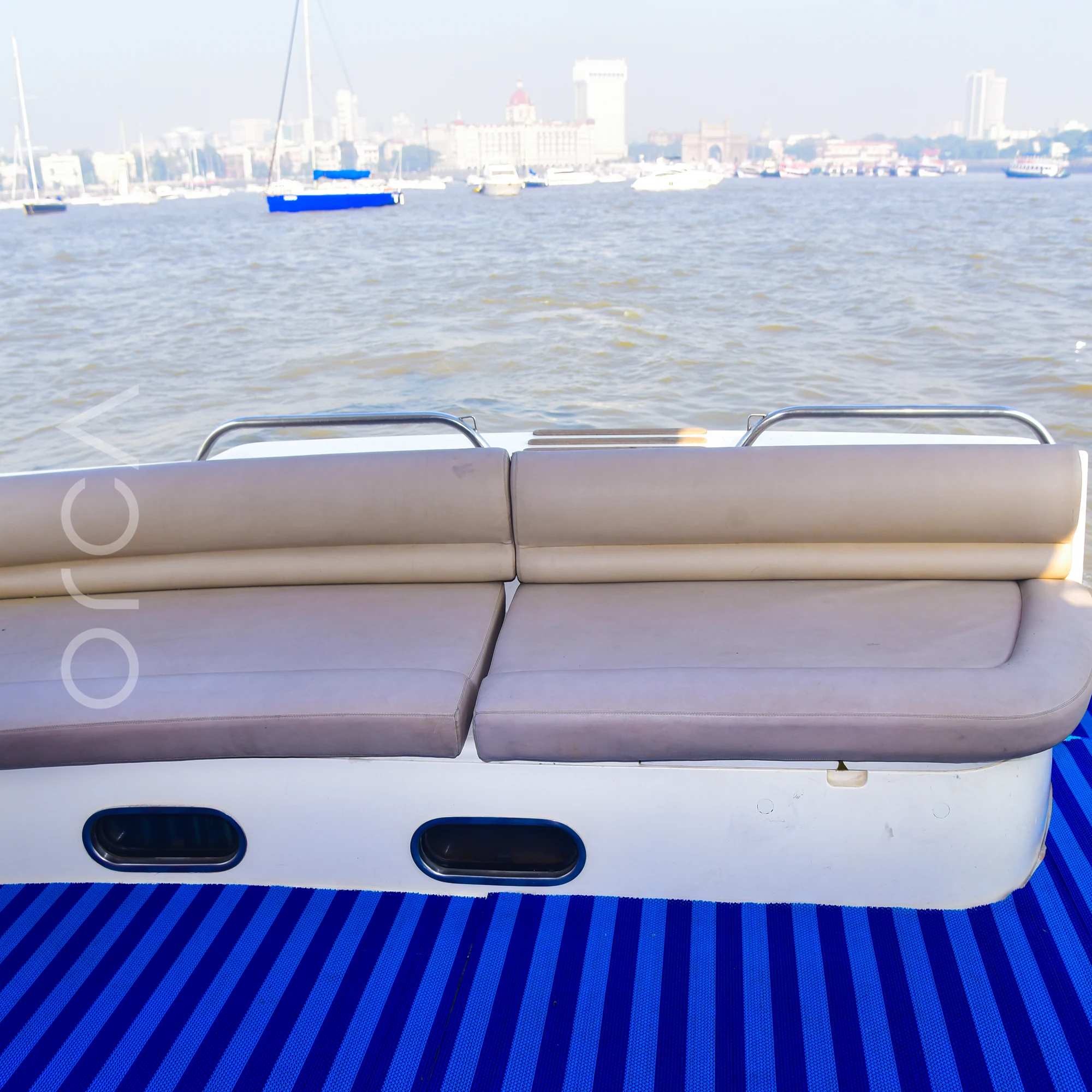 Bench seating on the aft deck of a Princess 61 motor yacht in Mumbai harbour, available to rent from Orca Sail.