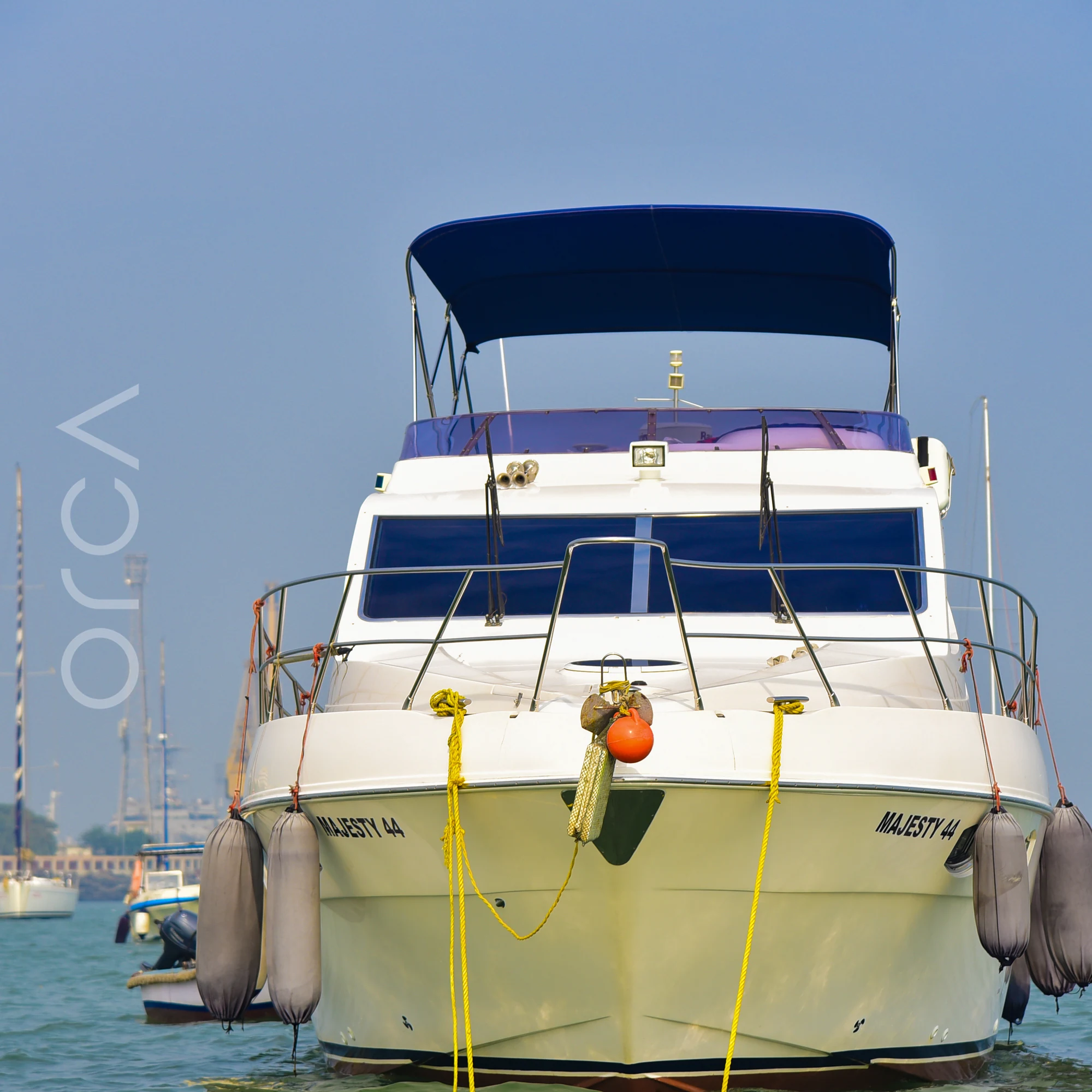 The Majesty 44 motor yacht seen bow-on at anchor in Mumbai harbour, available to rent from Orca Sail.