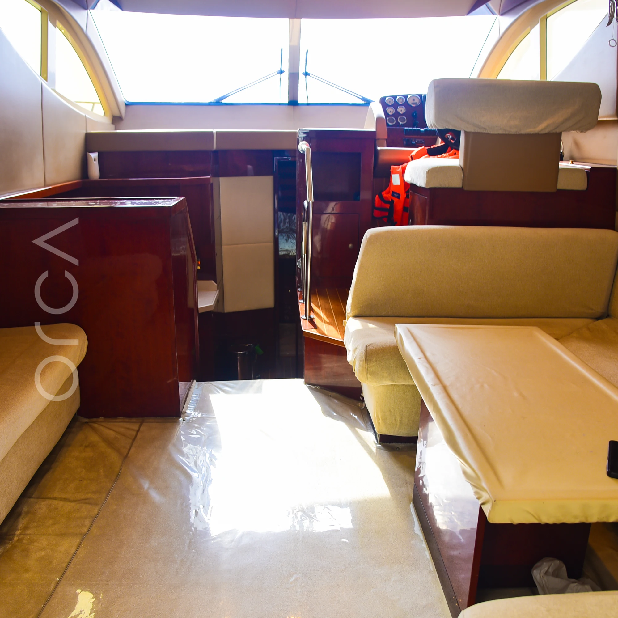 The main salon of a Majesty 44 motor yacht in Mumbai, with sofa seating, a dining table and the lower helm, available to rent from Orca Sail.