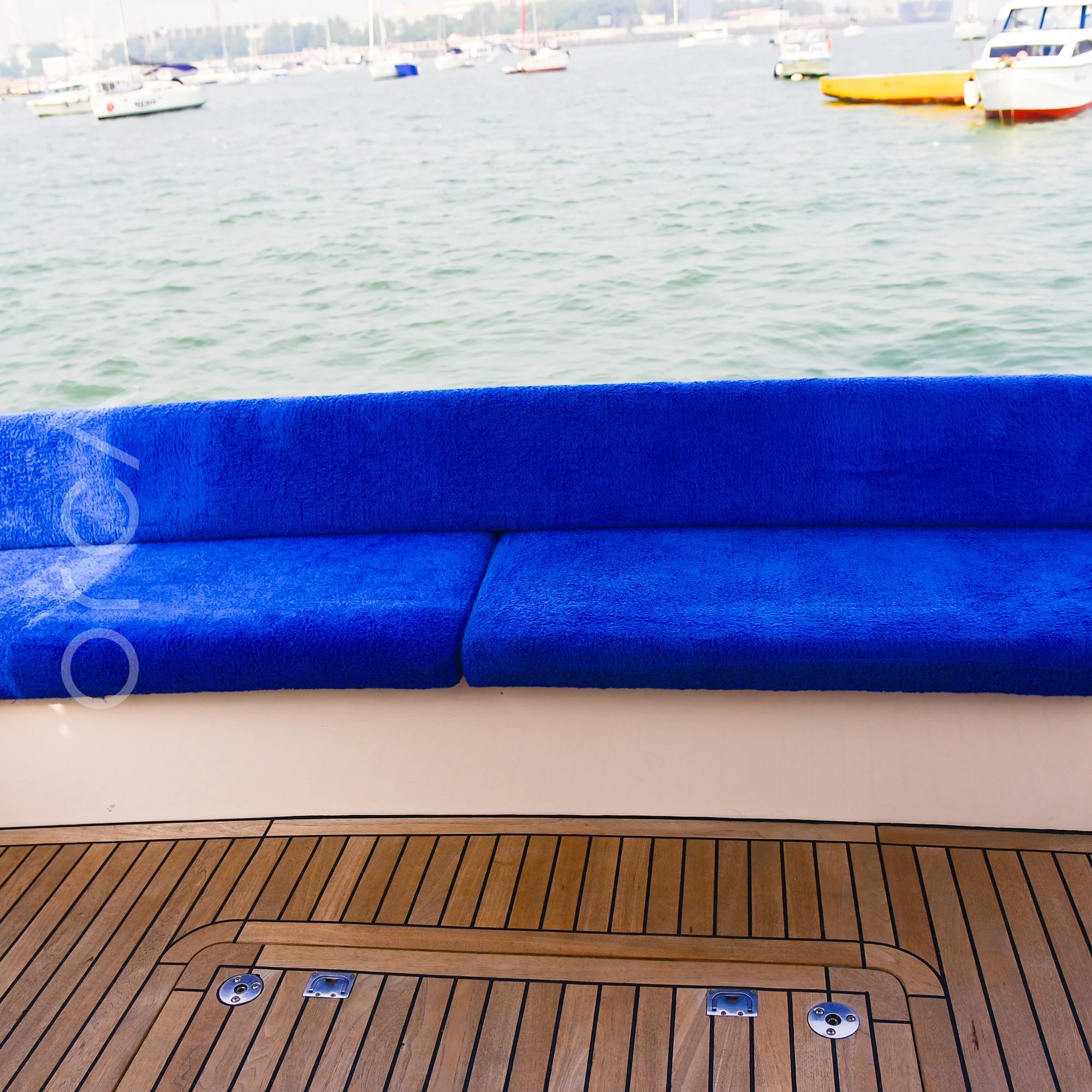 Bench seating on the aft deck of a Majesty 44 motor yacht in Mumbai harbour, available to rent from Orca Sail.