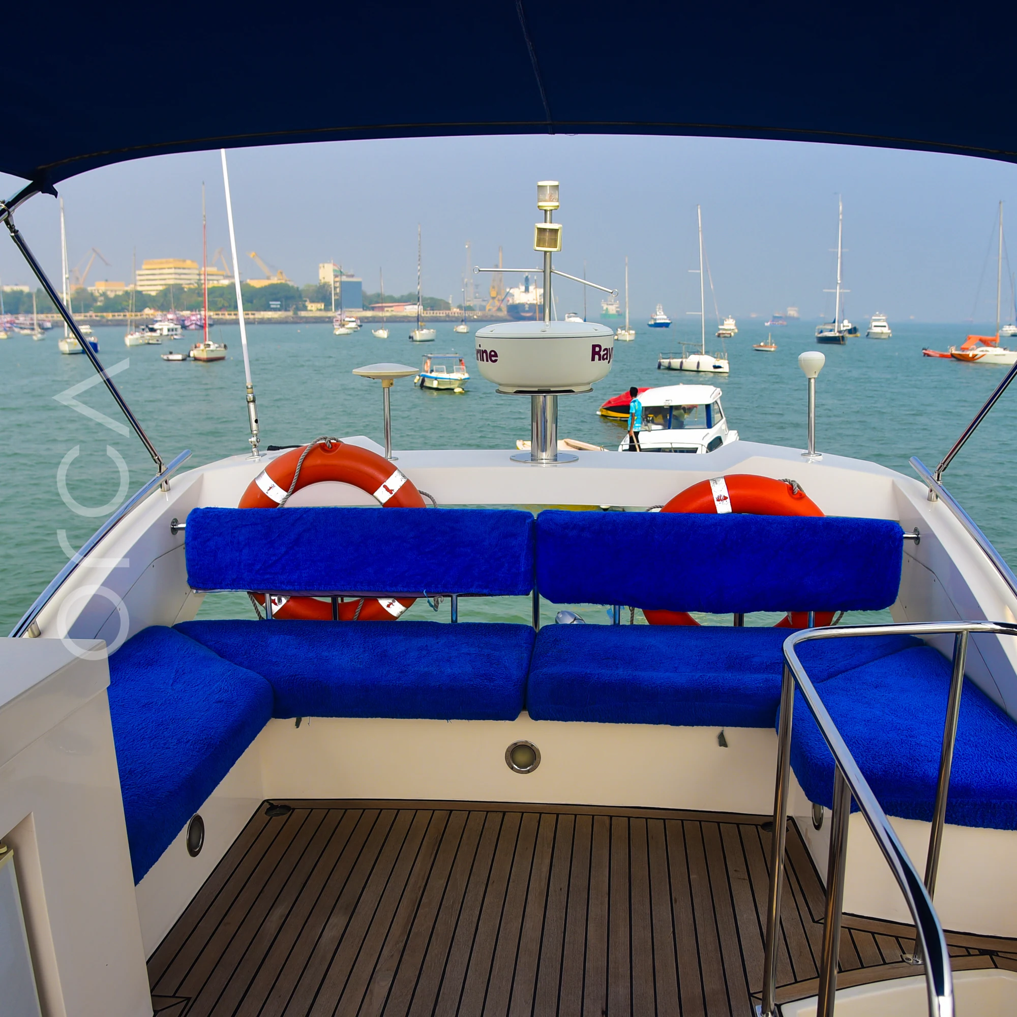 Seating on the flybridge of a Majesty 44 motor yacht in Mumbai, with life rings to hand, available to rent from Orca Sail.