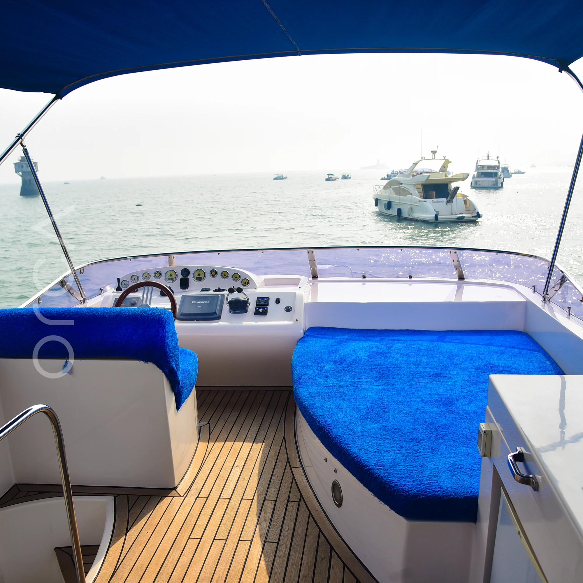 The flybridge helm and sunpad of a Majesty 44 motor yacht in Mumbai, available to rent from Orca Sail.