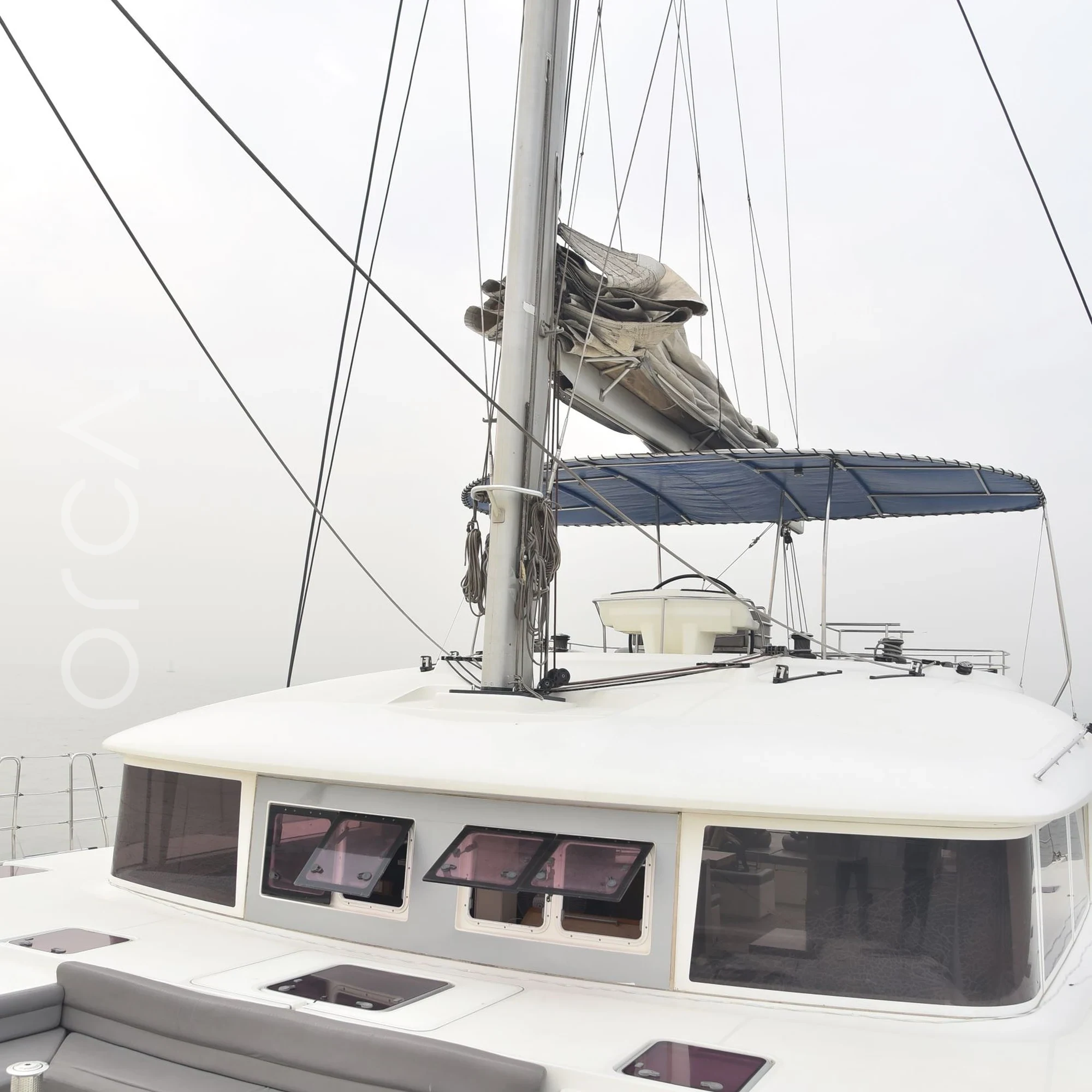The upper deck and helm area of a Lagoon 560 luxury sail yacht catamaran in Mumbai, available to rent from Orca Sail.
