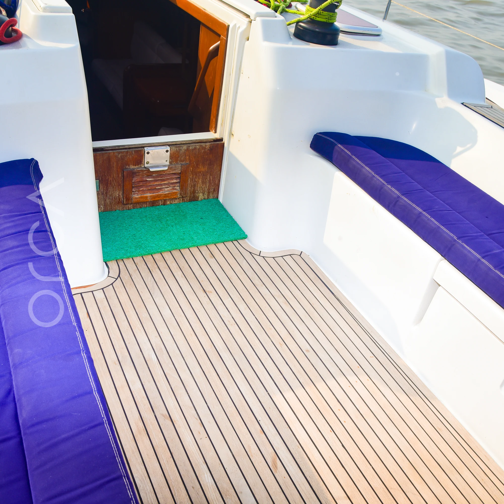 The cockpit of a Grand Soleil 45 sail yacht in Mumbai, with cushioned seating either side, available to rent from Orca Sail.