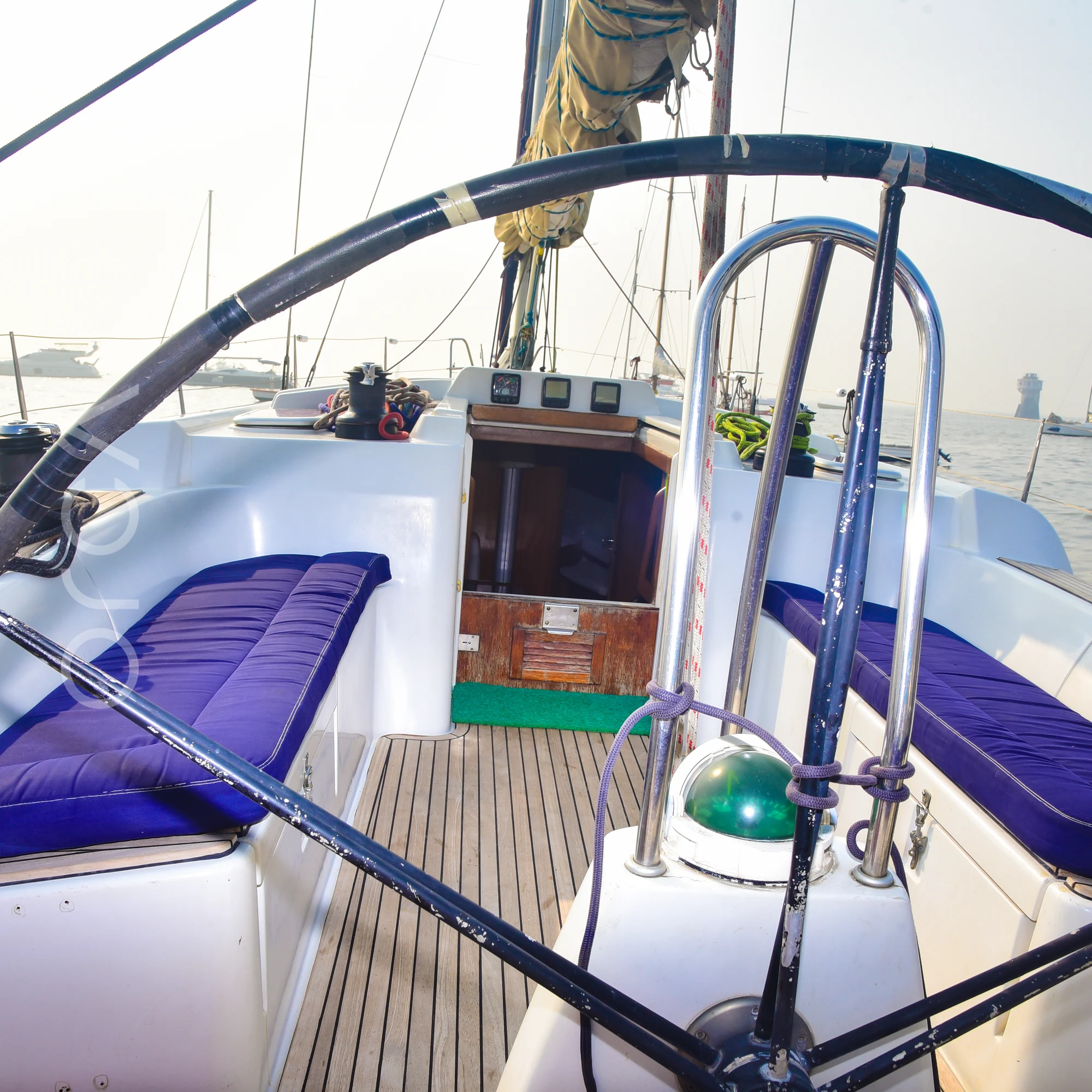 The wheel at the helm of a Grand Soleil 45 sail yacht in Mumbai, looking forward over the cockpit, available to rent from Orca Sail.