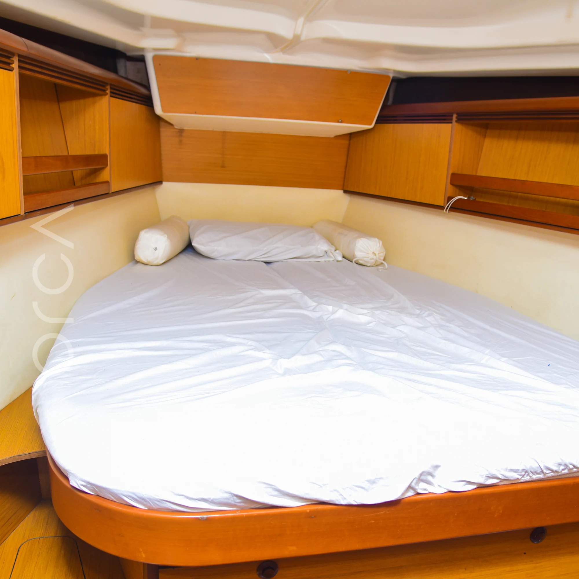 The forward cabin of a Jeanneau 45 sail yacht in Mumbai, with a double berth and wooden storage, available to rent from Orca Sail.