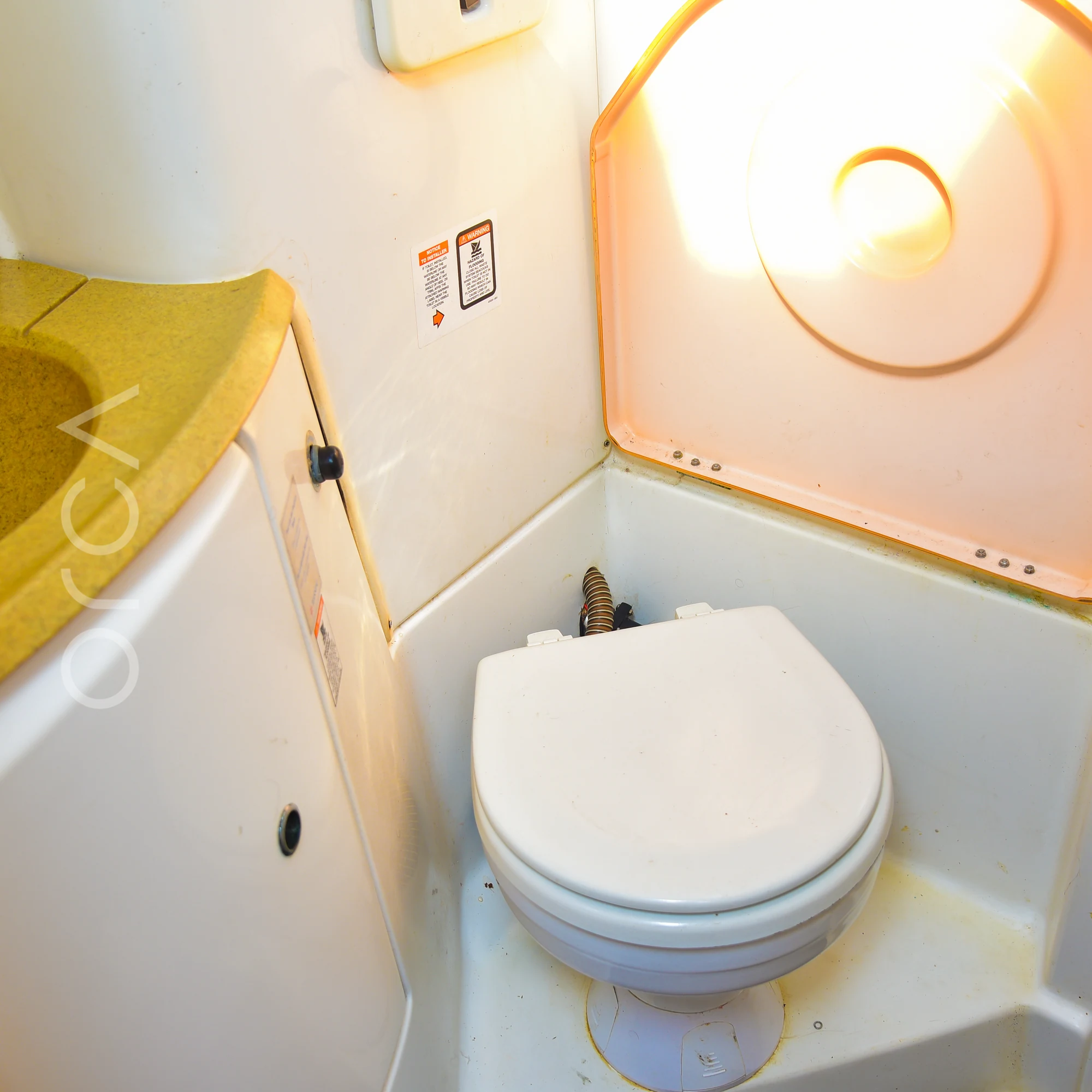 The bathroom aboard a Jeanneau 45 sail yacht in Mumbai, with a basin and a marine toilet, available to rent from Orca Sail.