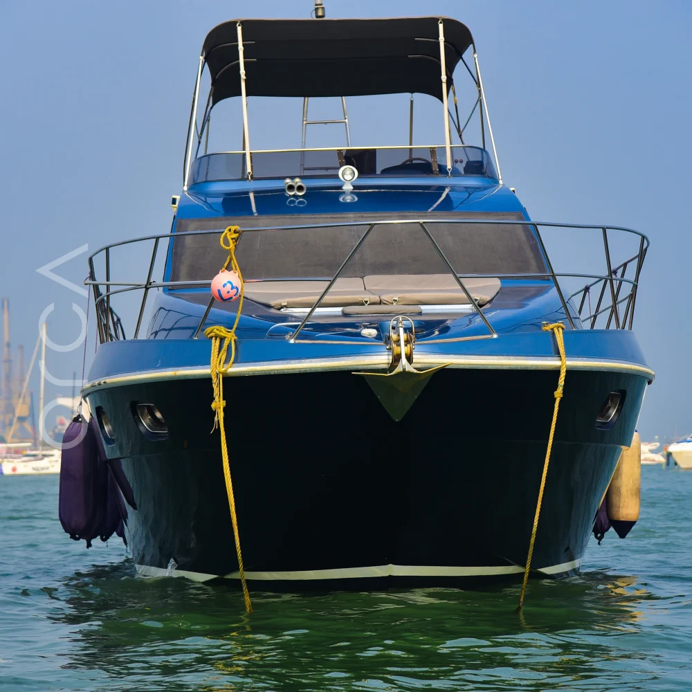 The Ambassador 47 motor yacht moored in Mumbai, seen bow-on, available to rent from Orca Sail.