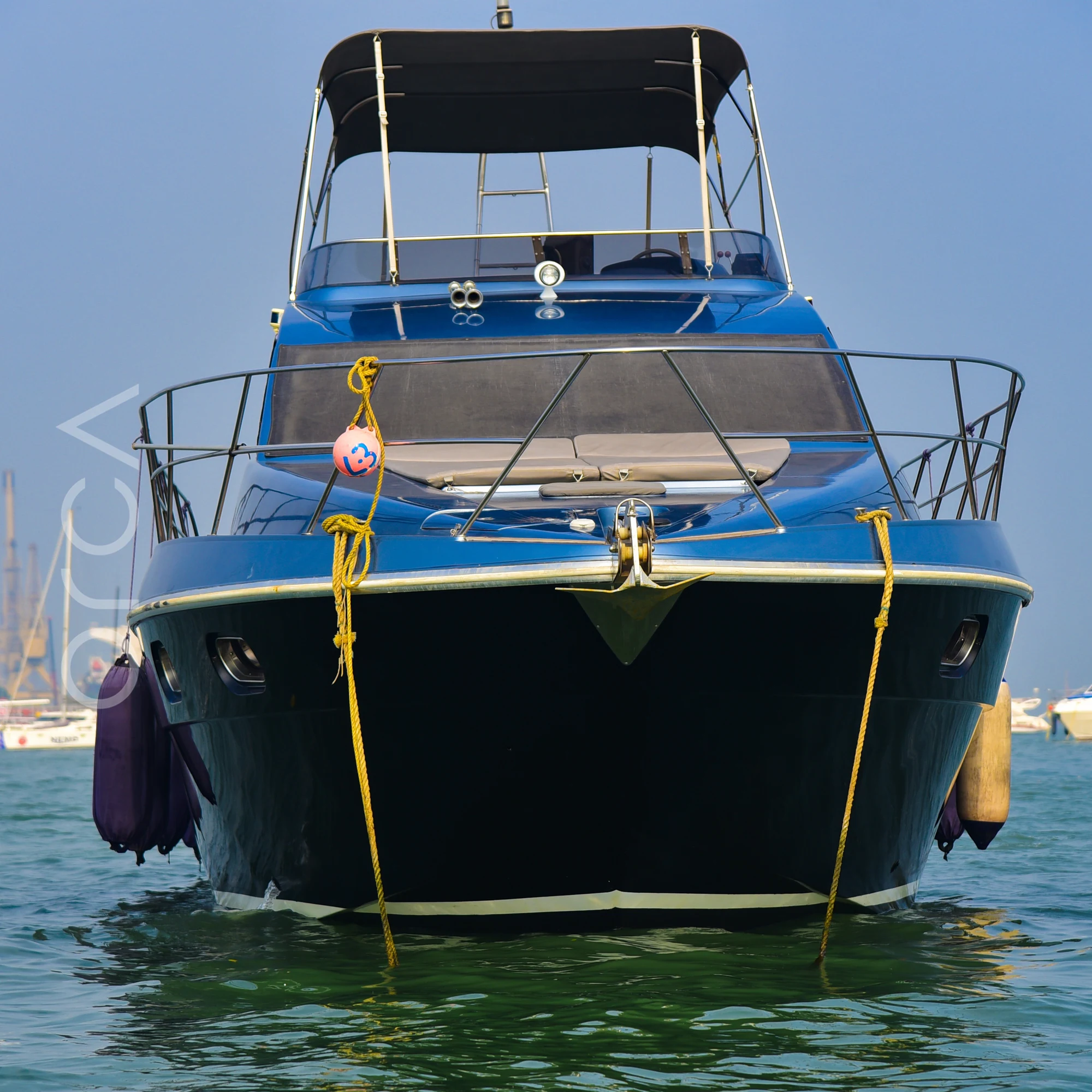 The Ambassador 47 motor yacht moored in Mumbai, seen bow-on, available to rent from Orca Sail.