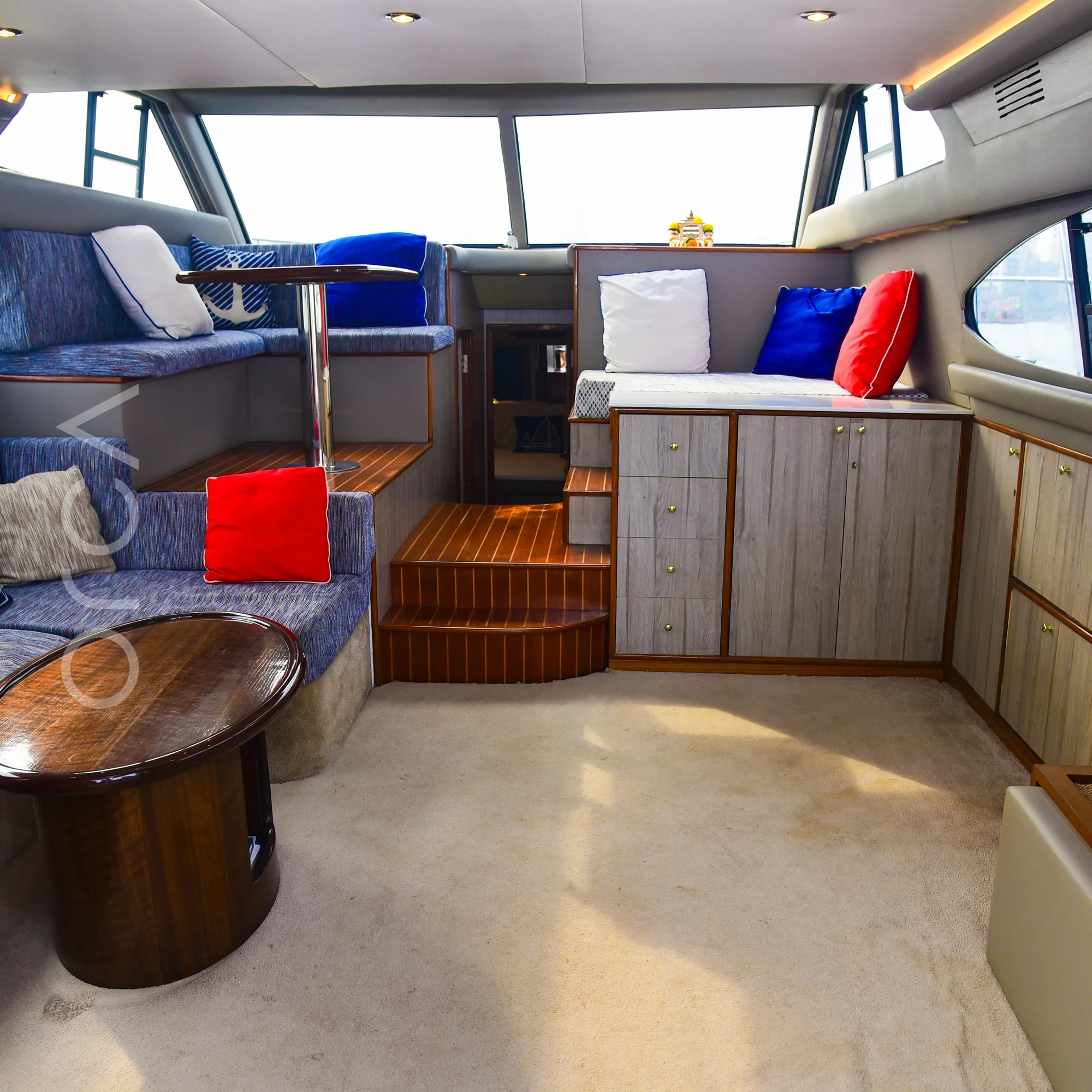 The main seating area aboard an Ambassador 47 motor yacht in Mumbai, available to rent from Orca Sail.