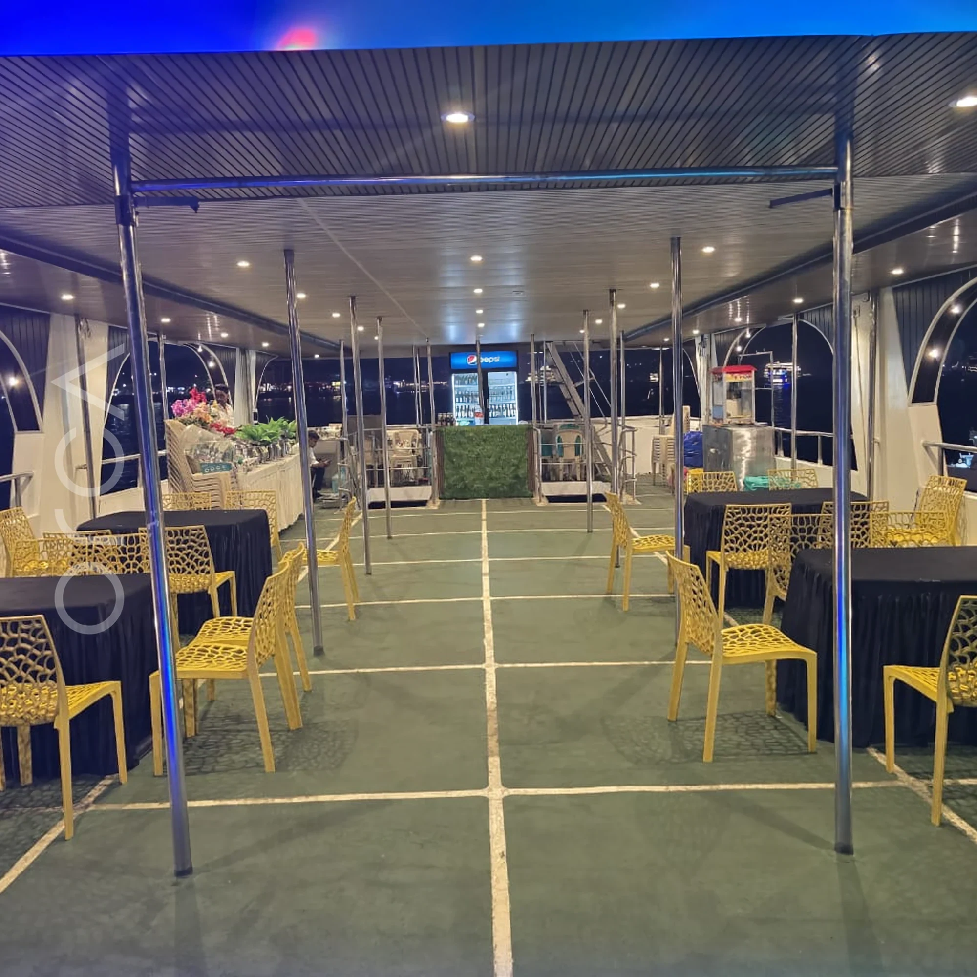 The main seating area aboard an Omsai party catamaran in Goa, available to rent from Orca Sail.